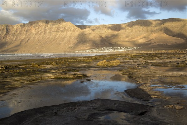 Late afternoon light on beach and cliffs La Caleta de Famara, Lanzarote, Canary islands, Spain, Europe