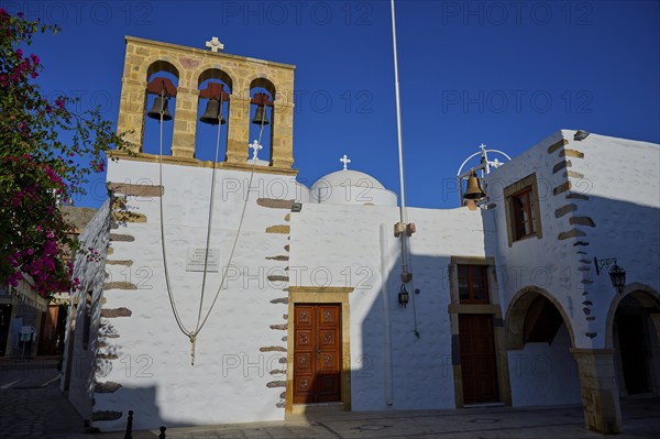 Agios Ioannis Prodromos Church, A church with a light-coloured stone bell tower and white walls on a Greek island under a blue sky, Skala, Patmos, Dodecanese, Greek Islands, Greece, Europe