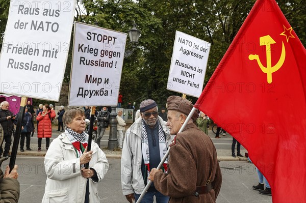 Demonstrators hold placards with slogans such as Stop war against Russia, Get out of Nato, Nato is the aggressor while talking to a man in Russian uniform holding a flag of the Soviet Union during the demonstration of the alliance Never again war in Berlin, 03/10/2024. The participants are against the stationing of US missiles in Germany, against the war in Ukraine and against German arms deliveries to Ukraine and Israel, Berlin, Berlin, Germany, Europe