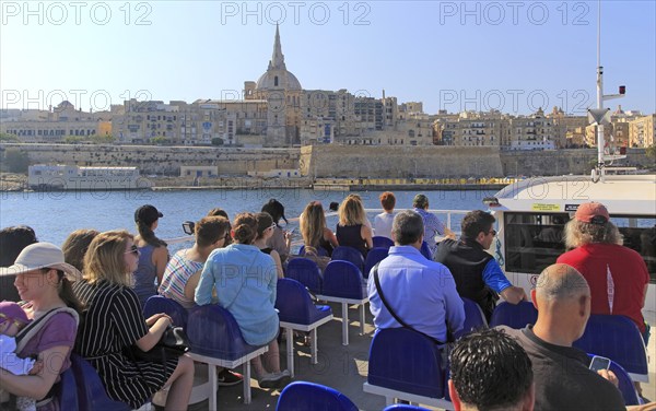 People onboard ferry boat crossing harbour from Sliema to Valletta, Malta, Europe