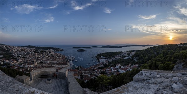 Panoramic view of a coastal town with a busy harbour and hills at sunrise, Hvar, Dalmatia, Croatia, Europe