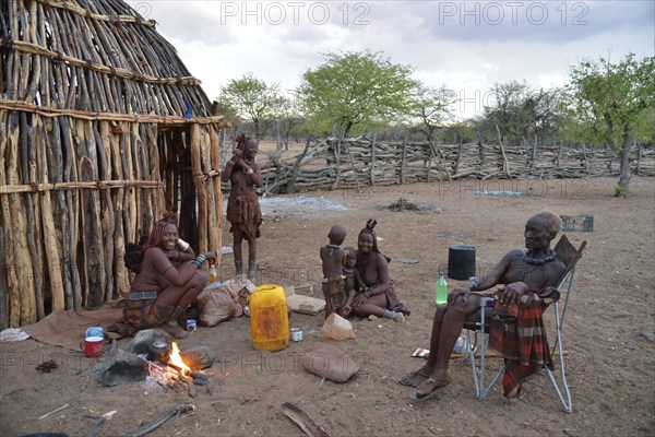 Chief Hikuminue Kapika, chief of the Namibian Himba, with his family at the fire in his kraal, Omuramba, Kaokoland, Kunene, Namibia, Africa