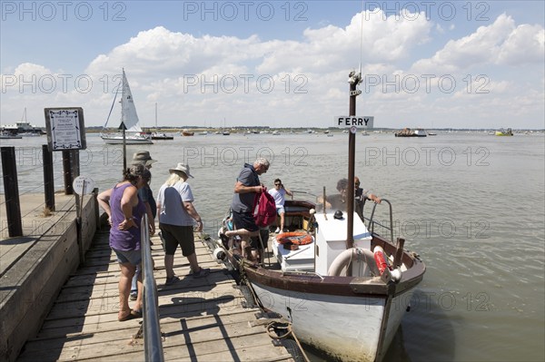 Passengers boarding River Deben foot passenger ferry boat at Bawdsey Quay, Suffolk, England, UK