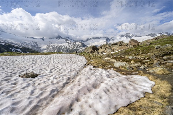 Picturesque mountain landscape with snow remains, mountain peaks with snow and glacier Schwarzensteinkees, Hornkees and Waxeggkees, summit Schwarzenstein, Hornspitzen and Großer Möseler, Berliner Höhenweg, Zillertal Alps, Tyrol, Austria, Europe