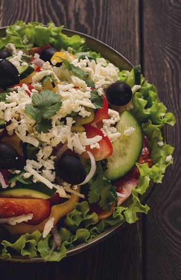 Traditional Bulgarian dish, Shopska salad, on a wooden table, salad of fresh vegetables, top view, close-up, no people, Bulgarian food, Bulgarian cuisine, salad, vegetables