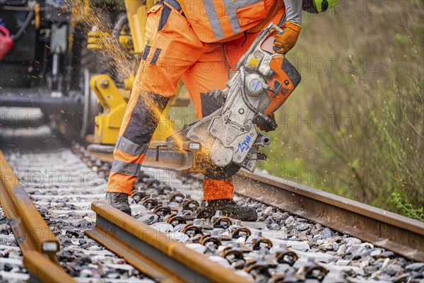 A construction worker cuts tracks with a grinder, sparks fly around, track construction, Hermann Hessebahn, Calw, Black Forest, Germany, Europe