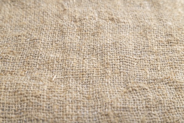 Fragment of smooth brown linen tissue. Side view, natural textile background and texture