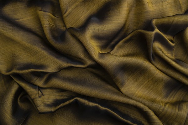 Fragment of yellow and green tissue. Side view, synthetic textile background and texture. wave concept, abstract