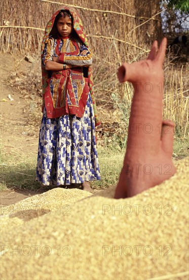 Girl from the Garasia tribe in Gujarat, India. She is standing near the representation of a horse deity