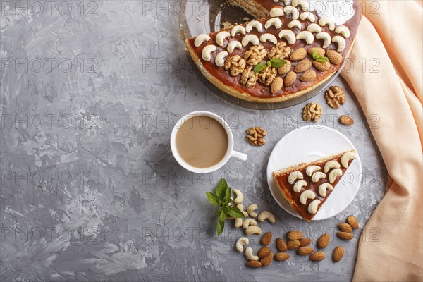 Homemade cake with caramel cream and nuts with cup of coffee on a gray concrete background. top view. flat lay, copy space