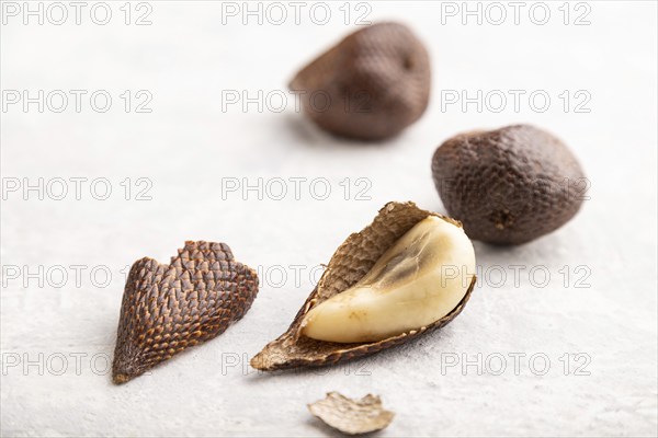 Salak or snake fruit on gray concrete background. Side view, close up, selective focus. Tropical, healthy food, summer, exotic, minimalism