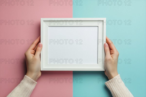 Woman's hands holding white empty picture frame on blue and pink background. Generative Ai, AI generated