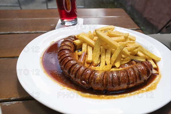 Currywurst with French fries served in a garden withe, Bavaria, Germany, Europe