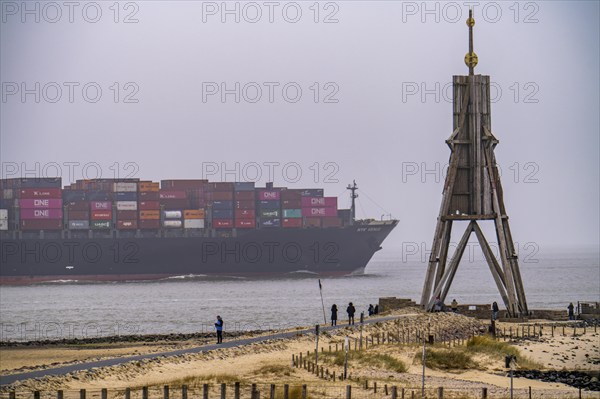 Thick fog in winter, hangs over the mouth of the Elbe into the North Sea, sea mark and landmark Kugelbake container ship NYK Venus, enters the Lower Elbe, Cuxhaven, Lower Saxony, Germany, Europe