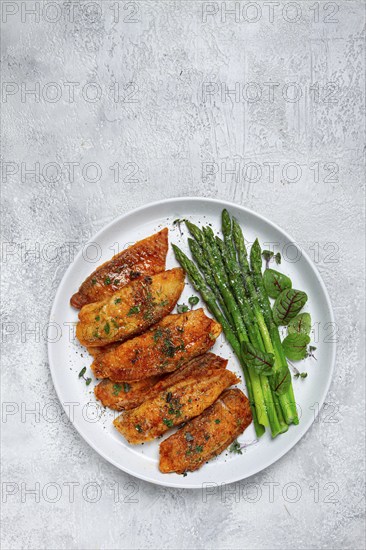 Fried fish fillet, tilapia with asparagus, homemade, no people