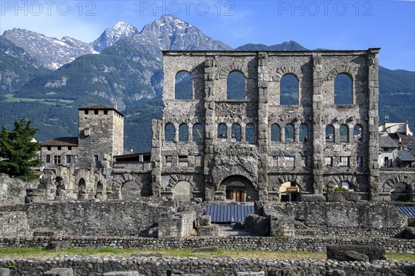 View of facade remains of wall ruins of ancient Roman theatre with window arches in open-air museum Aosta in Aosta Valley, in the background mountain range of high Alps, Aosta, Aosta Valley, Valle d'Aosta, Vallee d'Aoste, Italy, Europe