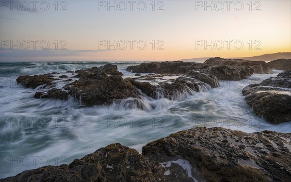 Waves washing over rocks by the sea, long exposure, coastal landscape at sunset, Playa Cocalito, Pacific coast, Nicoya Peninsula, Puntarenas province, Costa Rica, Central America