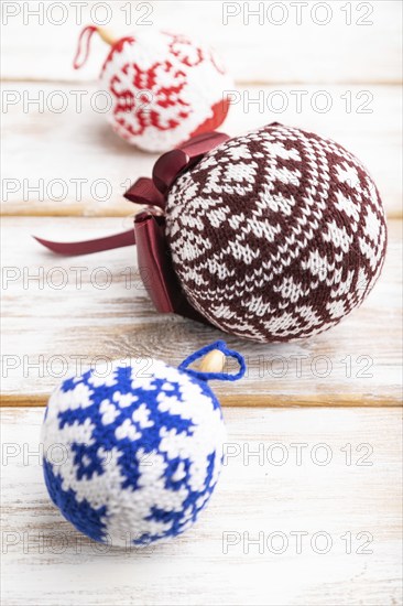 Christmas or New Year composition. Decorations, knitted balls, on a white wooden background. Side view, copy space, selective focus