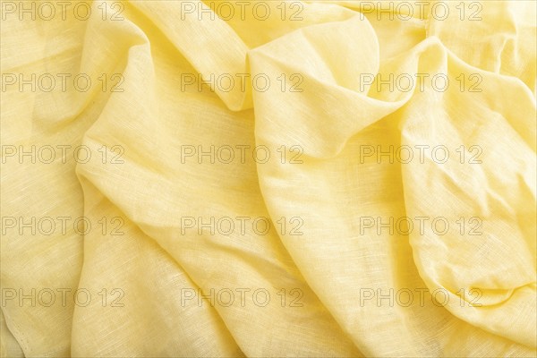 Fragment of yellow linen tissue. Top view, flat lay, natural textile background and texture. wave concept, abstract