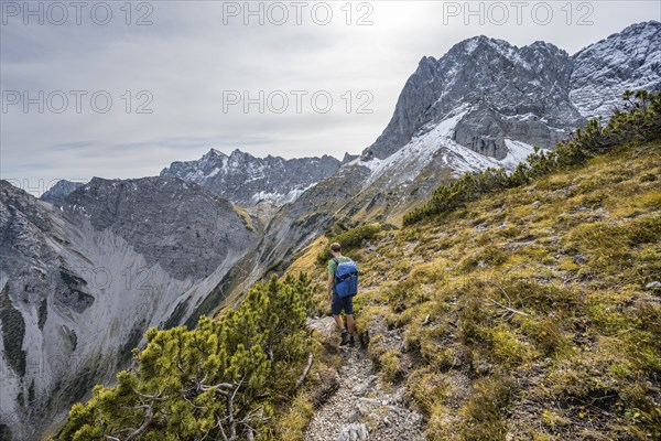 Mountaineers on a hiking trail on the ridge of Hahnkampl, mountain panorama with rocky steep peaks, view of summit Lamsenspitze, in autumn, Karwendel Mountains, Alpenpark Karwendel, Tyrol, Austria, Europe