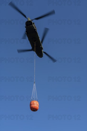 Forest fire in the German-Dutch border region near Niederkrüchten-Elmpt, in a nature reserve, use of fire-fighting helicopters, Boeing CH-47 Chinook helicopter, of the Dutch Air Force with extinguishing water tank, Bambi Bucket max