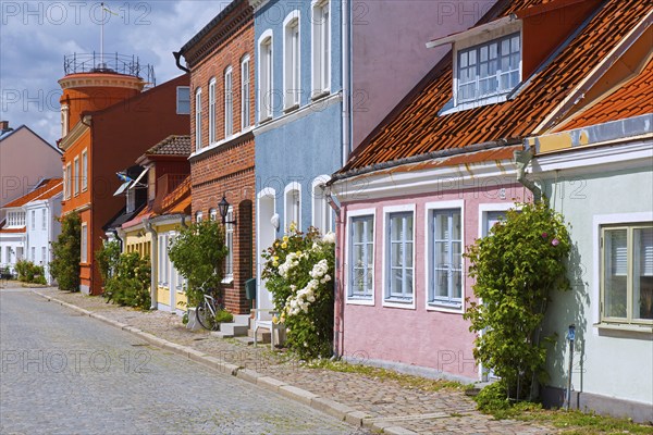 Cobbled street with colourful houses in pastel colours in the town Ystad in summer, Skåne, Scania, Sweden, Europe