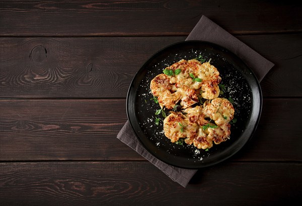 Steak, cauliflower, with cheese, spices, homemade, on a wooden table, dark background, close-up, top view, selective focus, no people