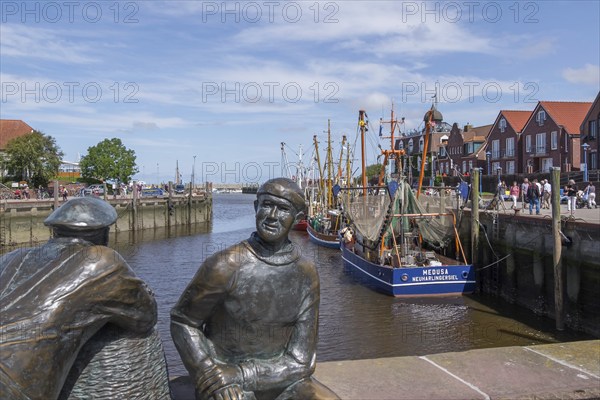 Sculpture of old and young fishermen at the cutter harbour Neuharlingersiel, East Frisia, Lower Saxony, Germany, Europe