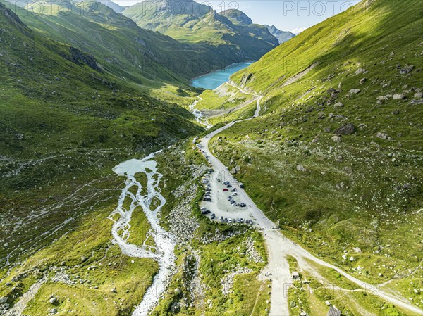 Parking lot at glacial lake Lac de Chateaupre, camper vans, lake Lac de Moiry in the back, aerial view, Valais, Switzerland, Europe