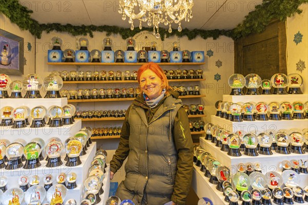 Saleswoman in a stand for snow globes at the Christmas market at St Stephen's Cathedral, Stephans-Platz, Vienna, Austria, Europe