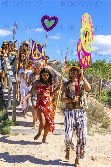 Colourfully dressed youths with musical instruments and banners form a love parade and promote the nightclub Pacha, Cala Comte, Ibiza, Balearic Islands, Mediterranean Sea, Spain, Europe