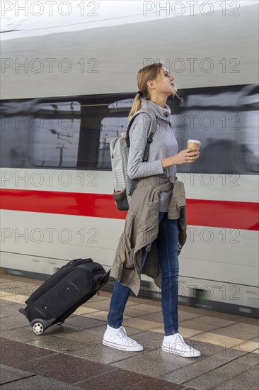 Young woman on the railway track while a train arrives