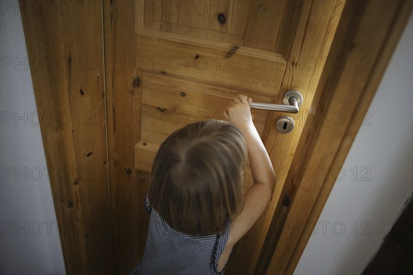 Symbolic photo: A small child opens a door in a flat. Berlin, 21.08.2024