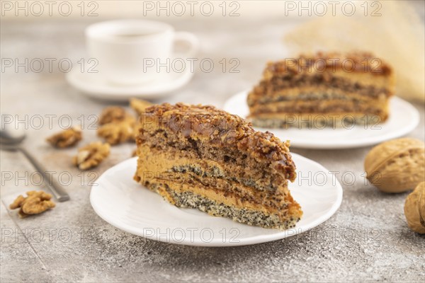 Walnut and hazelnut cake with caramel cream, cup of coffee on brown concrete background. side view, selective focus