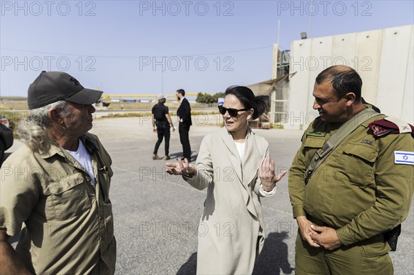 Annalena Bärbock (Alliance 90/The Greens, M), Foreign Minister, talks to Ami Shaked (l), Director of the Kerem Shalom border crossing, and a representative of the COGAT unit of the Israeli Ministry of Defence during a visit to the Kerem Shalom border crossing to the Gaza Strip on the Israeli side. Relief supplies are transported to the Gaza Strip by lorry from the border crossing in the tri-border region of Egypt, Israel and the Gaza Strip. Foreign Minister Bärbock is visiting Israel for the sixth time since the Hamas attack on Israel on 7 October to discuss the situation in Gaza and Israel once again