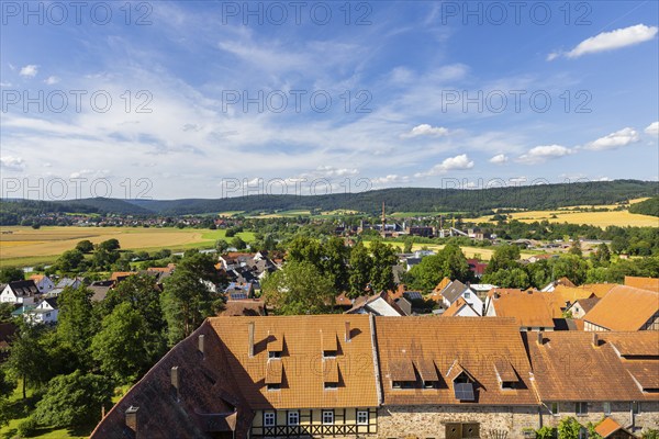 The Lippoldsberg Convent with the Church of St George and St Mary is a former Benedictine convent, which was the origin of the village of Lippoldsberg on the Weser in northern Hesse. In the background, the technical facilities of ProFagus GmbH for beech barbecue charcoal production in the district of Lippoldsberg in Bodenfelde, Lippoldsberg, Lippoldsberg, Hesse, Germany, Europe