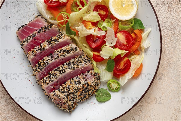 Fillet of red tuna meat, fried in sesame seeds, homemade, close-up, no people, on a wooden background