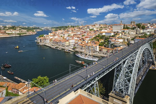 View of Porto city and Douro river with moored sailing ship and Dom Luis bridge I from famous tourist viewpoint Miradouro da Serra do Pilar on sunset. Porto, Vila Nova de Gaia, Portugal, Europe