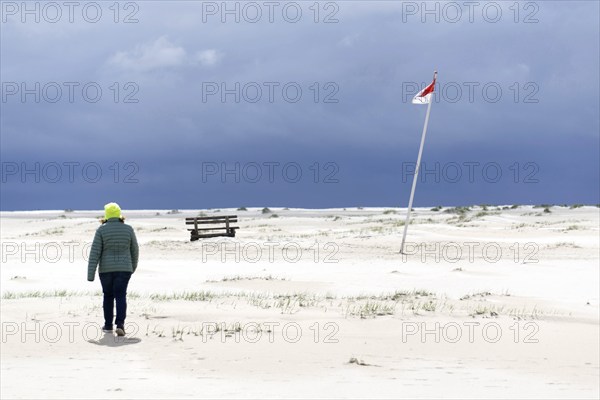 Woman with yellow cap, flag of Wittdün in Kniepsand, Amrum Island, 27 May 2021