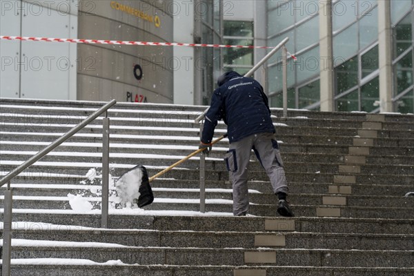 Onset of winter, winter service, clearing snow on the stairs of the Commerzbank building, Frankfurt, Hesse, Germany, Europe