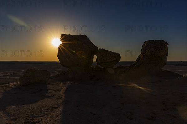 The morning sun shines through a striking rock formation in the Huqf stone desert, Arabian Peninsula, Sultanate of Oman