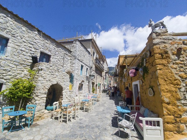 Sunny Mediterranean alley with alleyway cafés and locally run shops, Old Town, Areopoli, Areopolis, Tsimova, Itylo, Anatoliki Mani, Mani, Laconia, Peloponnese, Greece, Europe