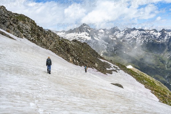 Mountaineer on a snowfield, descent from the summit of the Schönbichler Horn, view of snow-covered mountain peaks and the Zemmgrund valley, Berliner Höhenweg, Zillertal Alps, Tyrol, Austria, Europe