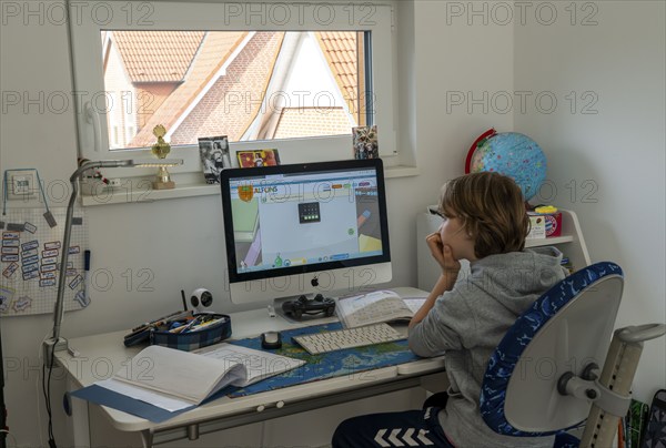 Young, primary school pupils, home learning, doing schoolwork, distance learning, virtual classroom, at home on the computer, effects of the corona crisis in Germany