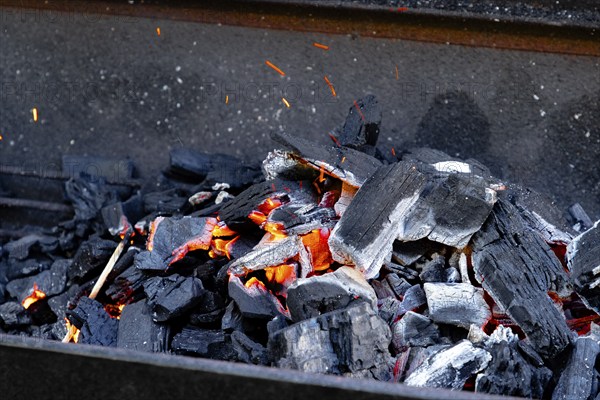 Hot glowing charcoal with sparks and flames, ready for grilling