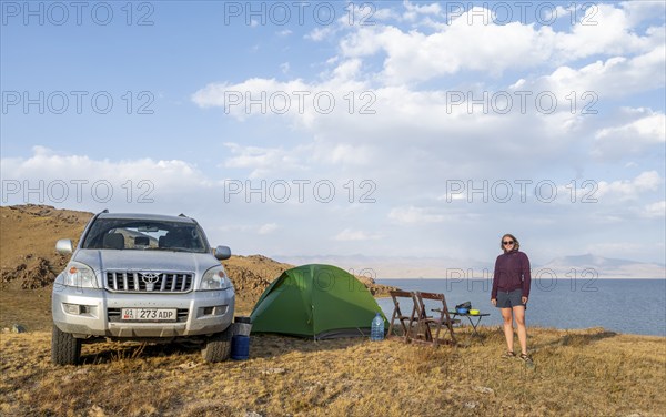 Hiker in front of a tent, camping in the highlands, Song Kul mountain lake, Naryn region, Kyrgyzstan, Asia