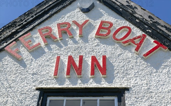 Red lettering detail of pub sign Ferry Boat Inn, Felixstowe Ferry, Suffolk, England, UK