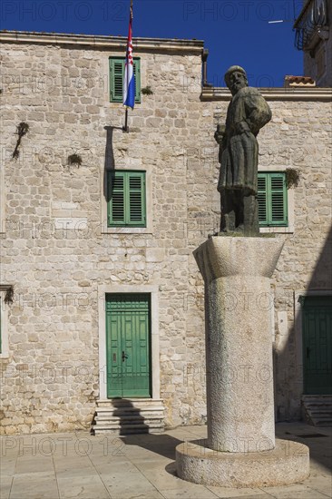 Statue of historic figure Giorgio da Sebenico / Juraj Dalmatinac in front of an old stone building, Cathedral Square, Sibenik, Croatia, Europe