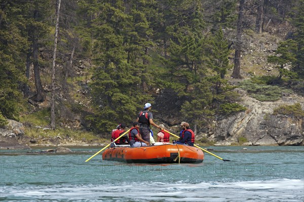 Tourists in inflatable raft rafting on the Bow River near Banff, Alberta, Canada, North America