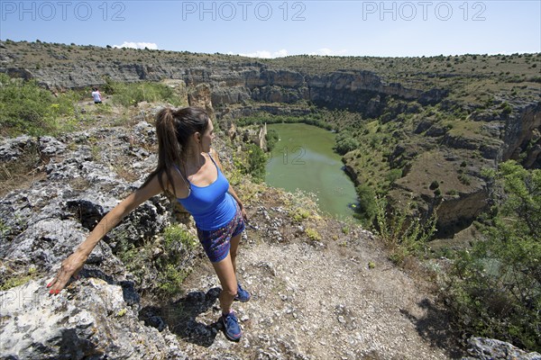 Castilian woman, 48 years old, looking at the gorge and the river Duratón, canoes on the water, on the left the Franciscan monastery La Hoz, Natural Park Hoces del Rio Duratón, province Segovia, Castilla y León, Spain, Europe